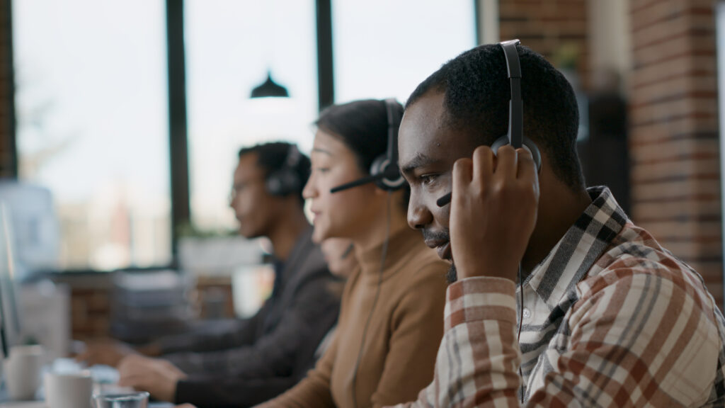 Equipo de servicio al cliente brindando asistencia telefónica en un entorno de oficina moderna